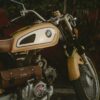 a yellow motorcycle parked next to a red wall